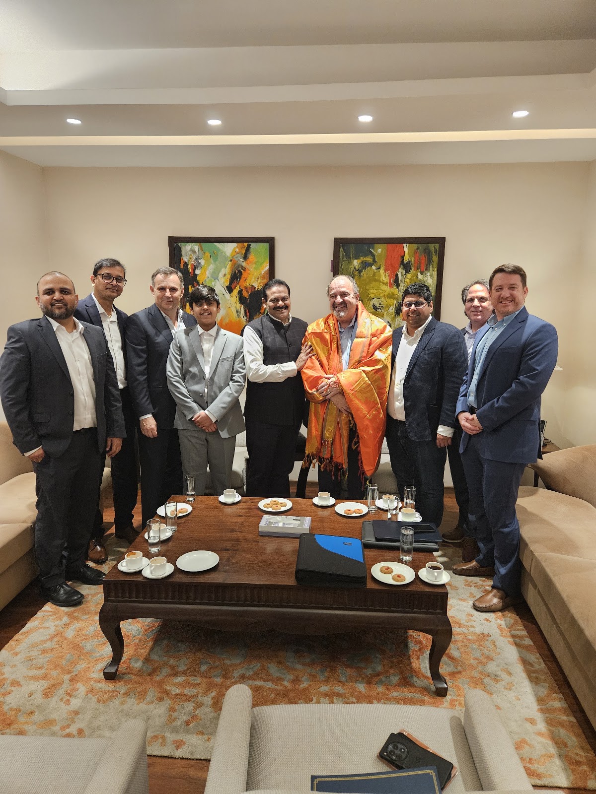 Mission group photographed in a meeting-room setting during the stated India mission