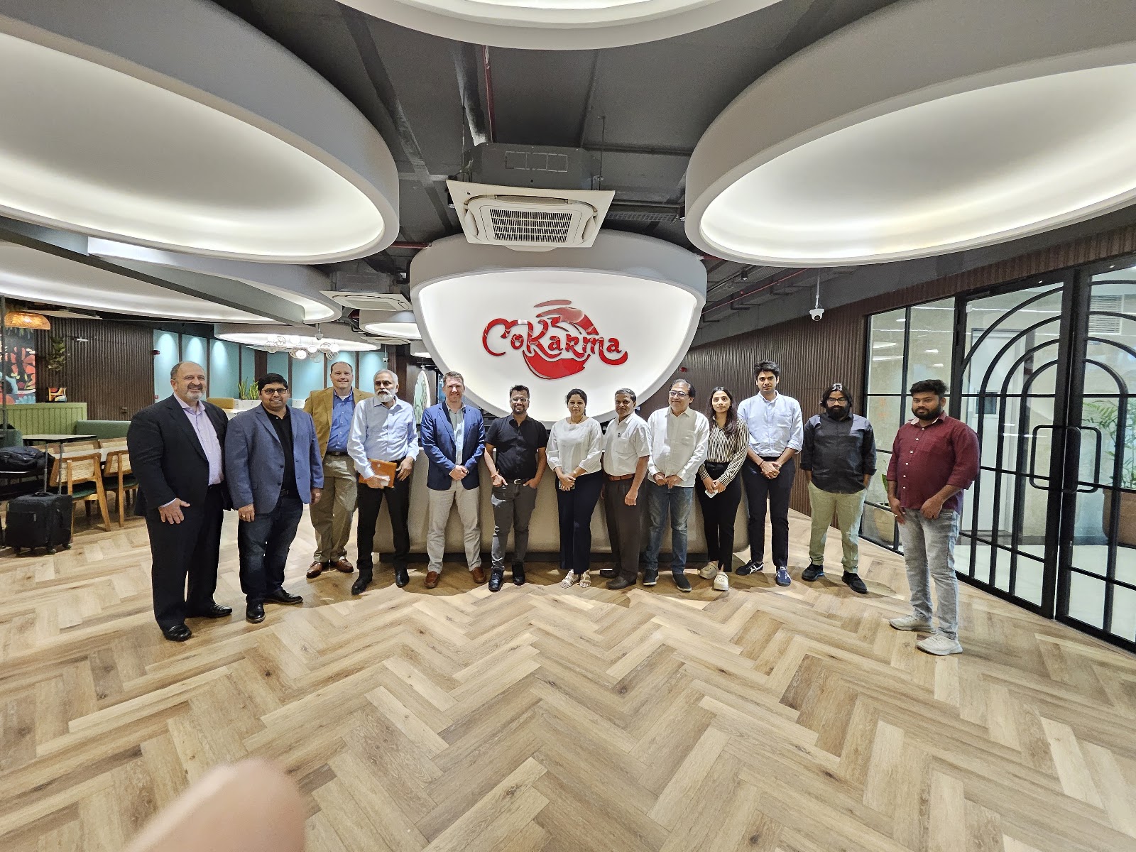 Mission group photographed beneath CoKarma signage