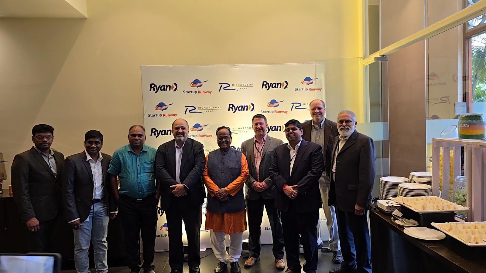 Mission group pictured in front of an event wall carrying City of Richardson, Ryan, and Startup Runway branding